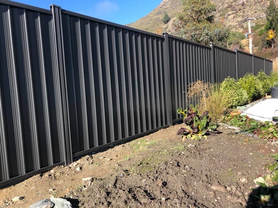 Dark Colorsteel fencing beside a garden with mountain backdrop, Queenstown
