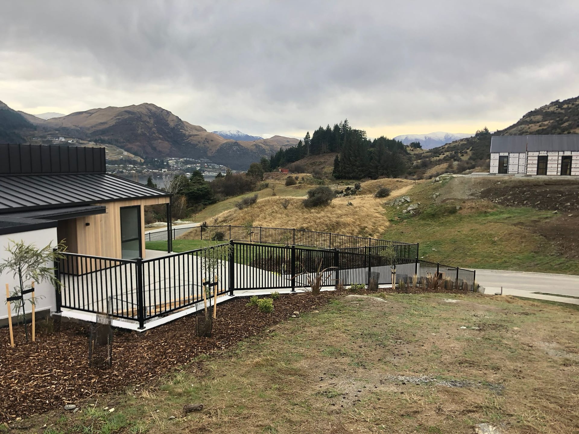 Black tubular security fencing with panoramic Queenstown mountain view